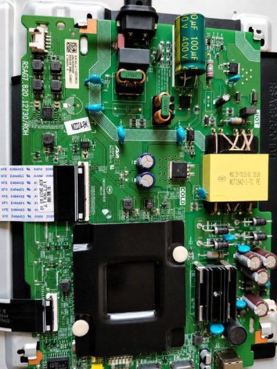 Radial and SMD aluminum electrolytic capacitors mounted on a green PCB power supply circuit board